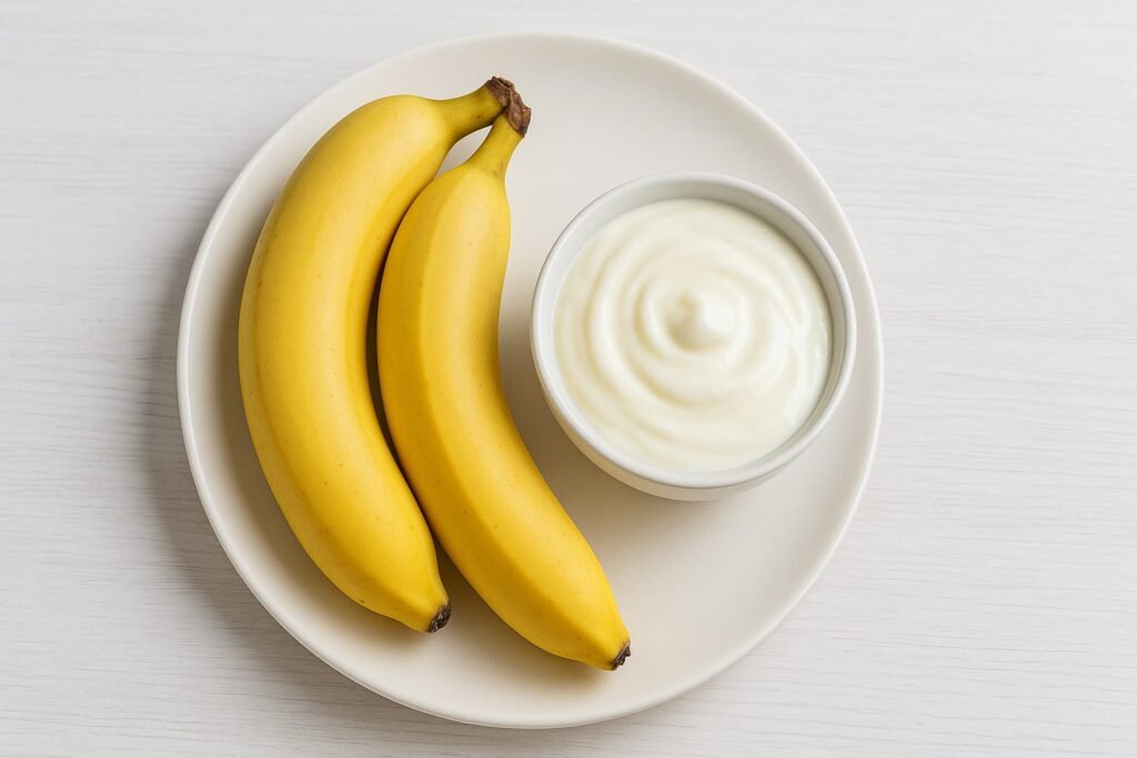 Plate par do kela aur ek bowl me dahi rakha hua hai.